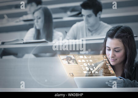 Student using tablet pc to take notes in lecture hall Stock Photo