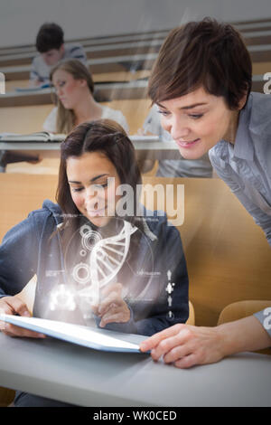 Student sitting while teacher is explaining on tablet pc in lecture hall Stock Photo