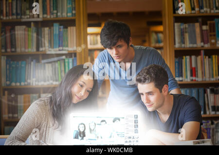 Students watching something on laptop in library in college Stock Photo
