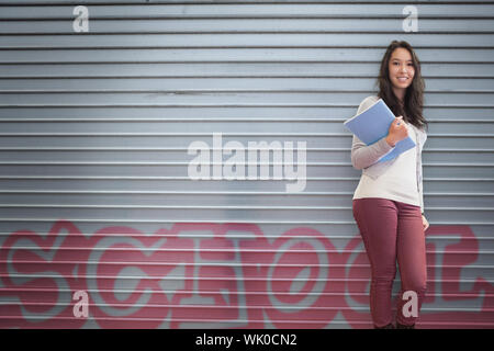 Happy student holding notebook posing Stock Photo