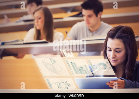 Student using tablet pc to take notes in lecture hall Stock Photo