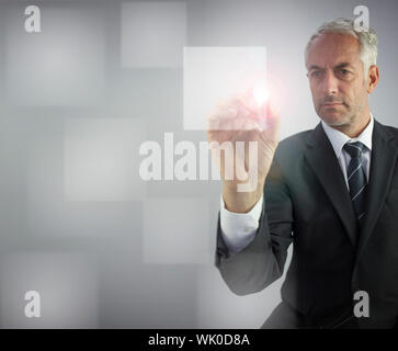 Serious businessman touching empty pane on digital screen Stock Photo
