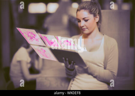Woman using tablet pc standing in college library beside study desks Stock Photo