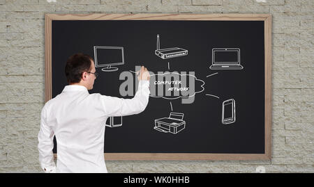 young businessman drawing computer network on blackboard Stock Photo