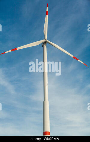 Wind turbine against a blue hazy sky in a conceptual image of renewable and alternative energy resources to save the environment Stock Photo