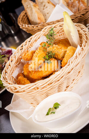 Crumbed chicken nuggets in a basket Stock Photo