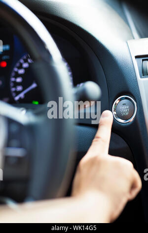 finger pressing the Engine start stop button Stock Photo