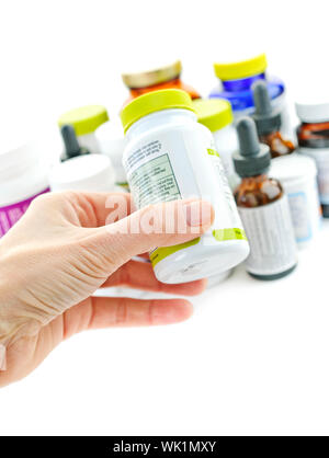 Hand holding medicine bottle to read label Stock Photo