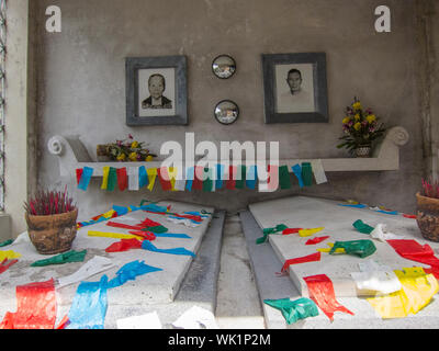 The altar area inside a typical mausoleum at the Chinese North Cemetery in Manila, Philippines. Pictures of the departed are on the wall above the tom Stock Photo