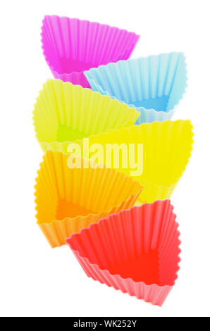 Arrangement of Silicone Rainbow Colored Cupcake Molds In a Row isolated on white background Stock Photo