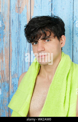 Young man in front of vintage wooden background with towel Stock Photo