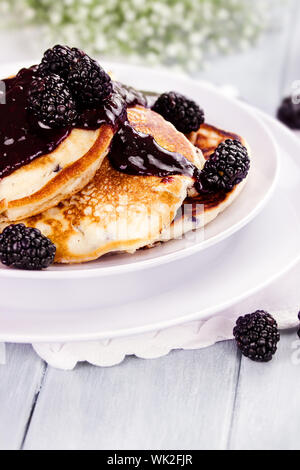 Delicious golden pancakes with fresh blackberries and blackberry jam. Extreme shallow depth of field. Stock Photo