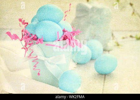 Muted textured Easter eggs in a blue tin bucket. Shallow depth of field. Stock Photo