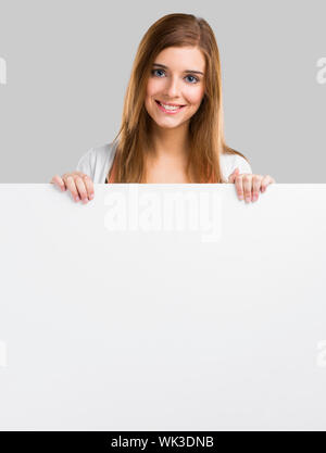 Young and beautiful woman holding a big blank board, isolated over white background Stock Photo