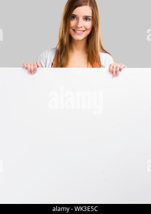 Young and beautiful woman holding a big blank board, isolated over white background Stock Photo