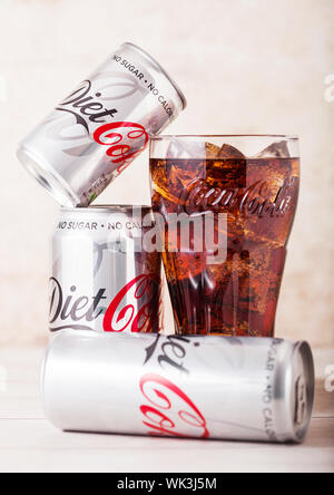 LONDON, UK - AUGUST 03, 2018: Aluminium tins and original glass of Diet Coke Coca Cola soft drink on wood. Most popular drink in the world. Stock Photo