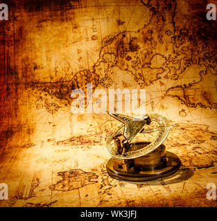 Vintage still life. Vintage compass lies on an ancient world map. Stock Photo