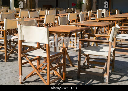terrace with canvas chairs and wooden tables Stock Photo