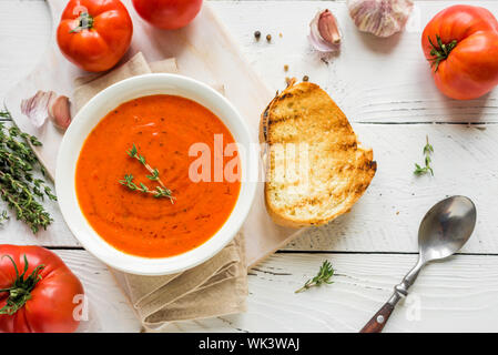 Tomato Soup with grilled cheese sandwich, top view, copy space. Homemade tomato soup with thyme. Stock Photo