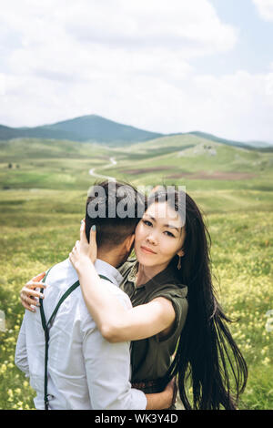 Portrait of a beautiful young adult girl hugging a man Stock Photo