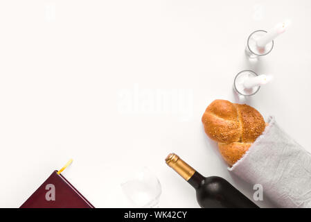 Shabbat or Shabath concept. Challah bread, shabbat wine, book and candles, top view, copy space. Traditional Jewish Shabbat ritual. Shabbat Shalom. Stock Photo