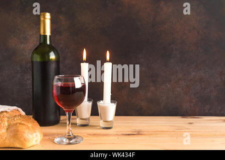 Shabbat or Shabath concept. Challah bread, shabbat wine and candles, copy space. Traditional Jewish Shabbat ritual. Shabbat Shalom. Stock Photo