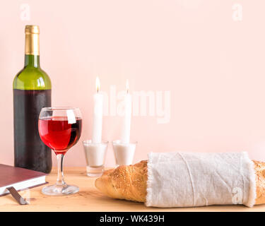 Shabbat or Shabath concept. Challah bread, shabbat wine, book and candles, copy space. Traditional Jewish Shabbat ritual. Shabbat Shalom. Stock Photo