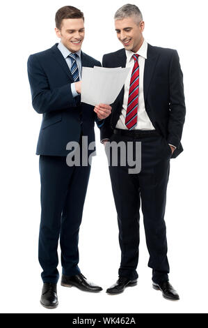 Smiling business executives checking documents Stock Photo