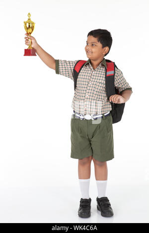 Indian schoolboy showing a trophy and smiling Stock Photo