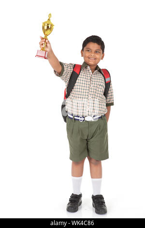 Schoolboy showing a trophy and smiling Stock Photo