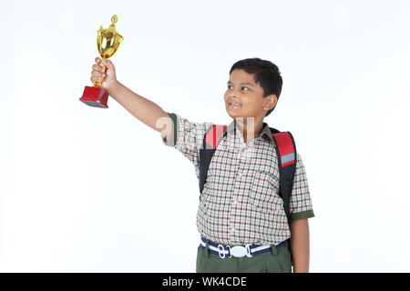 Indian schoolboy showing a trophy and smiling Stock Photo
