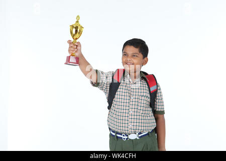 Schoolboy showing a trophy and smiling Stock Photo