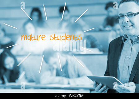 The word mature students against lecturer standing in front of his class in lecture hall Stock Photo