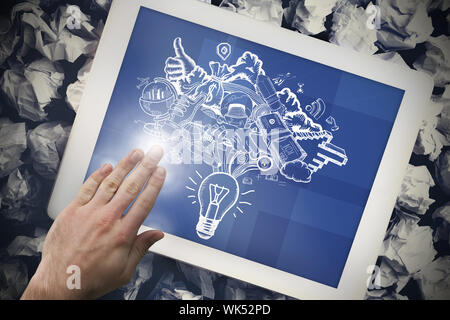 Composite image of hand touching tablet showing ideas doodle Stock Photo
