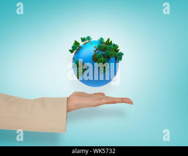 Female hand presenting blue earth against blue vignette Stock Photo