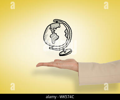 Female hand presenting globe against yellow vignette Stock Photo