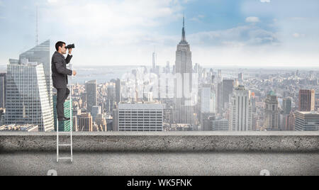 Businessman standing on ladder against balcony overlooking city Stock Photo