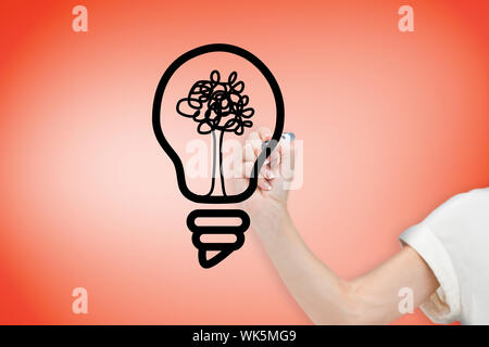 Composite image of businesswoman drawing light bulb against orange Stock Photo