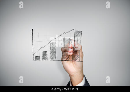 Composite image of businessman drawing graph against grey vignette Stock Photo