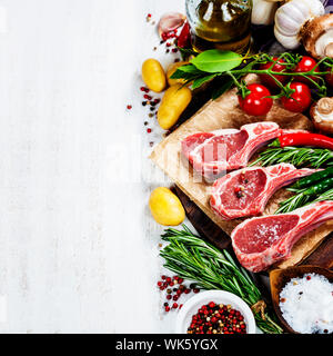 Raw lamb cutlets with vegetables, herbs and spices Stock Photo
