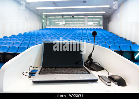 Laptop on the rostrum in conference hall. Stock Photo