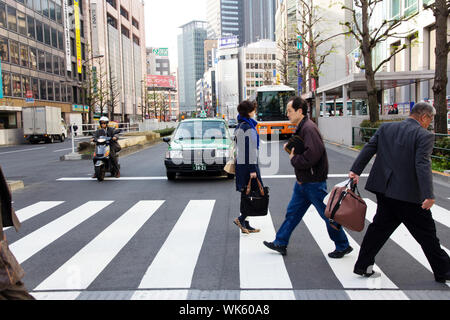 Tourists and business people crossing the street Stock Photo