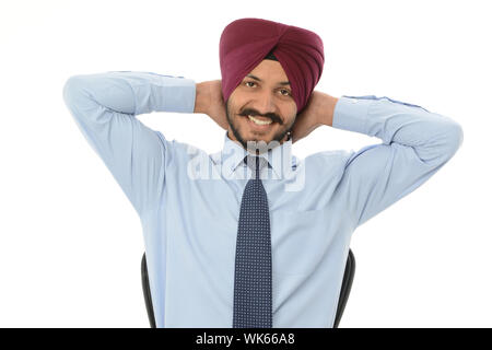 Portrait of an Indian businessman smiling with his hands behind head Stock Photo