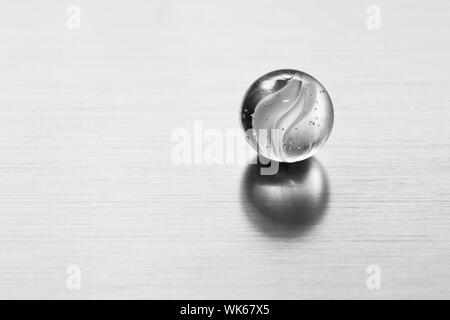 Transparent glass ball on metal surface. Conceptual modern background for sciene, technology, business etc Stock Photo