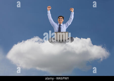 Businessman sitting on clouds and using a laptop concept of cloud computing Stock Photo