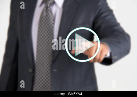 Mid section of a businessman pressing startplay button on virtual screen Stock Photo