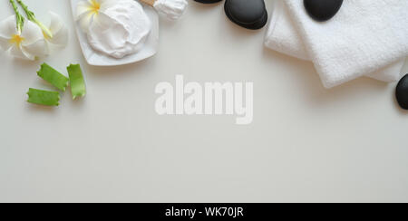 Spa therapy concept : Top view of black stones and towels for massages on white background Stock Photo