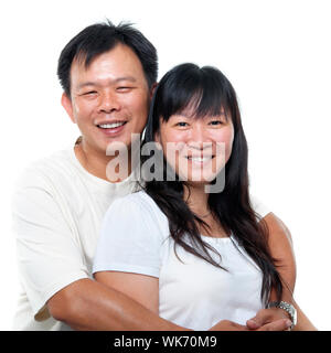 Happy southeast Asian mature couple hugging and smiling, isolated on white background. Stock Photo