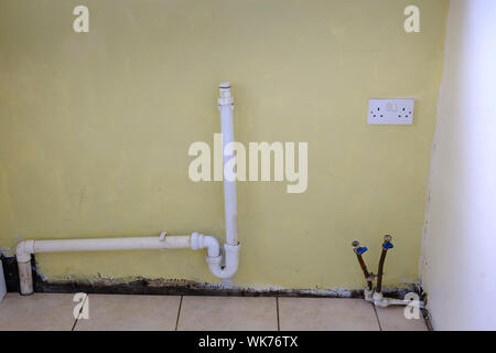 Empty room kitchen plumbing for washing machine Stock Photo