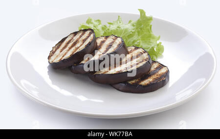 Some fried slices of eggplant with fresh green lettuce on the plate Stock Photo